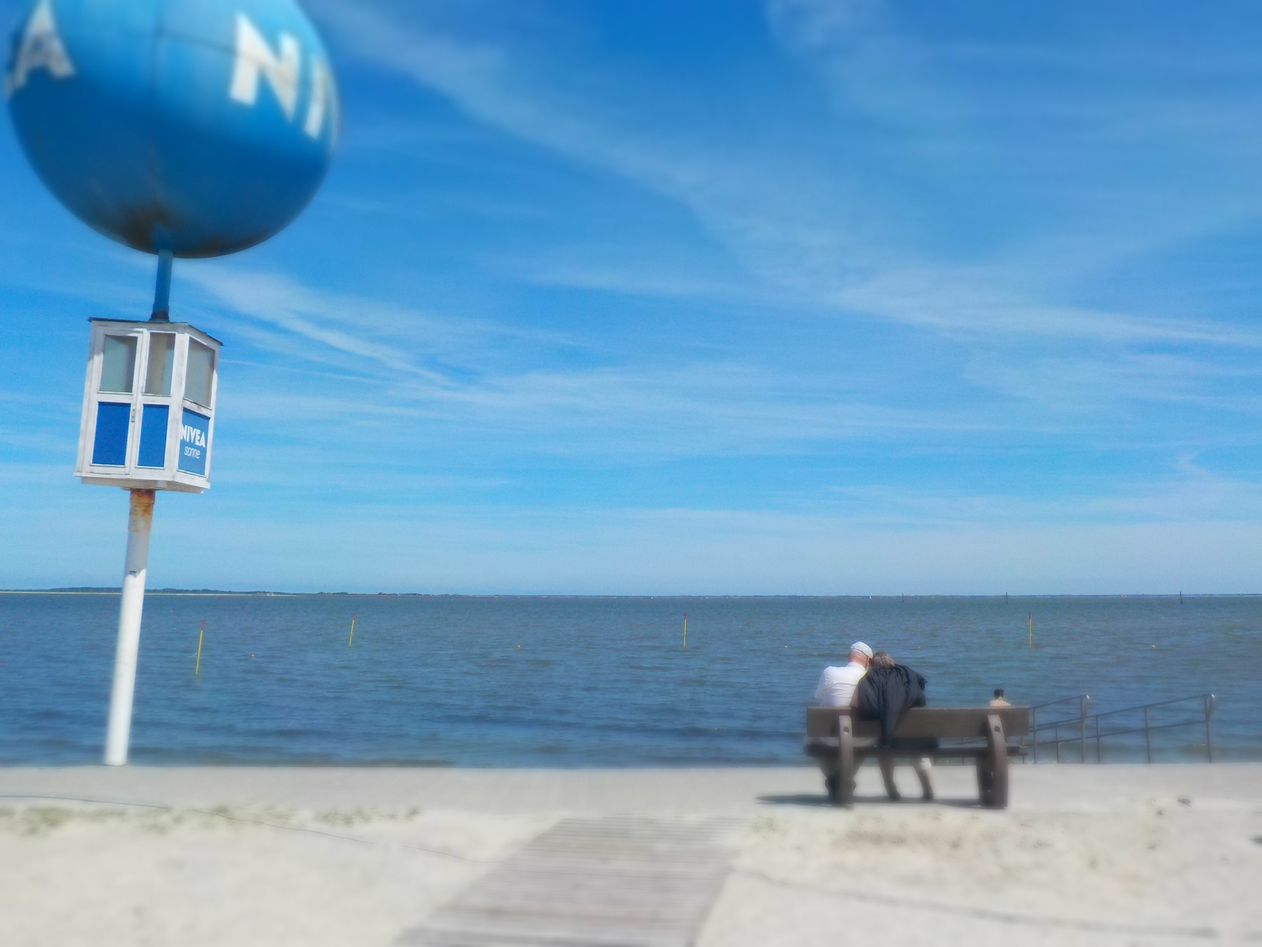 Blick auf die Nordsee mit einer Sitzbank an der Promenade